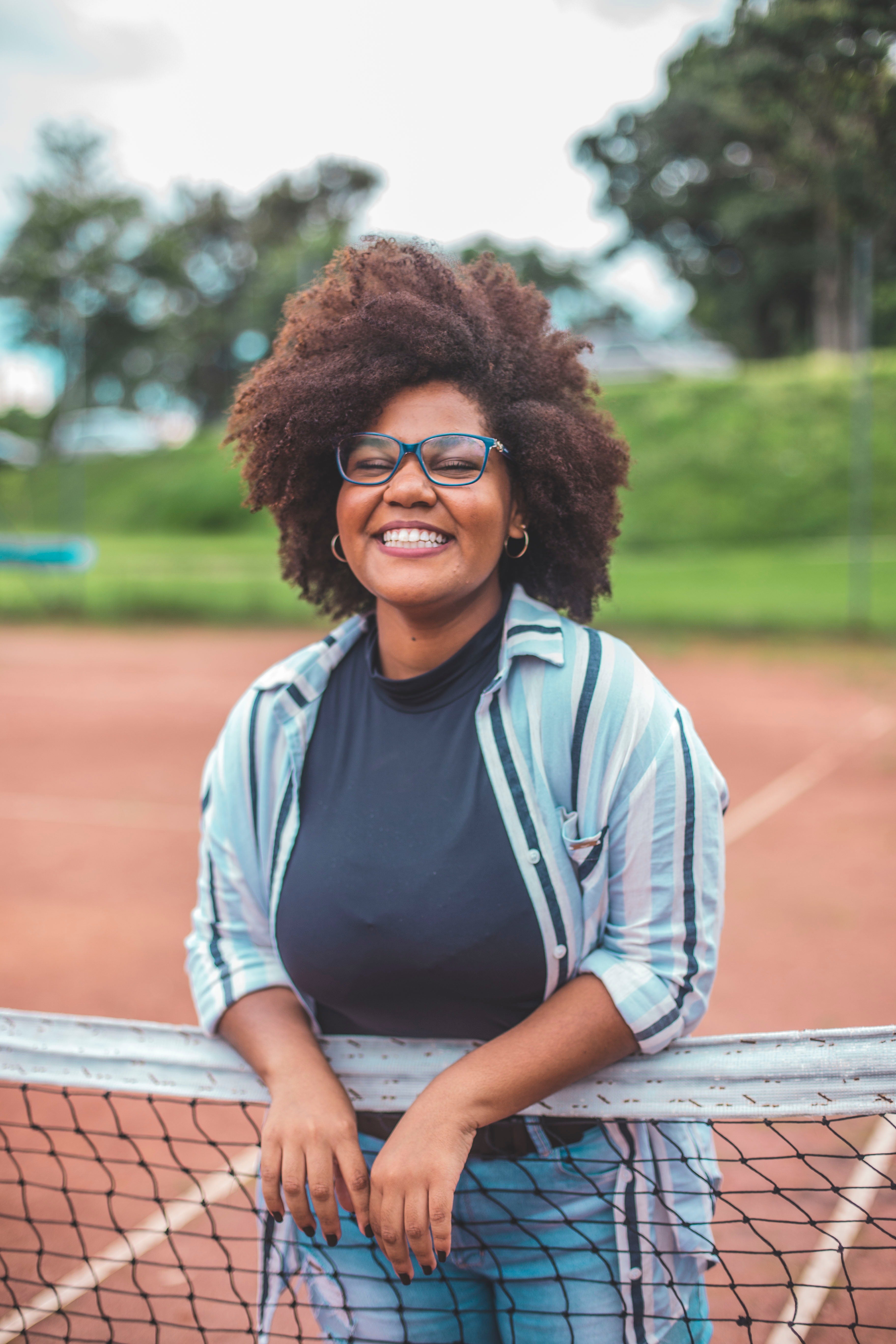 Smiling woman with glowing skin on tennis court