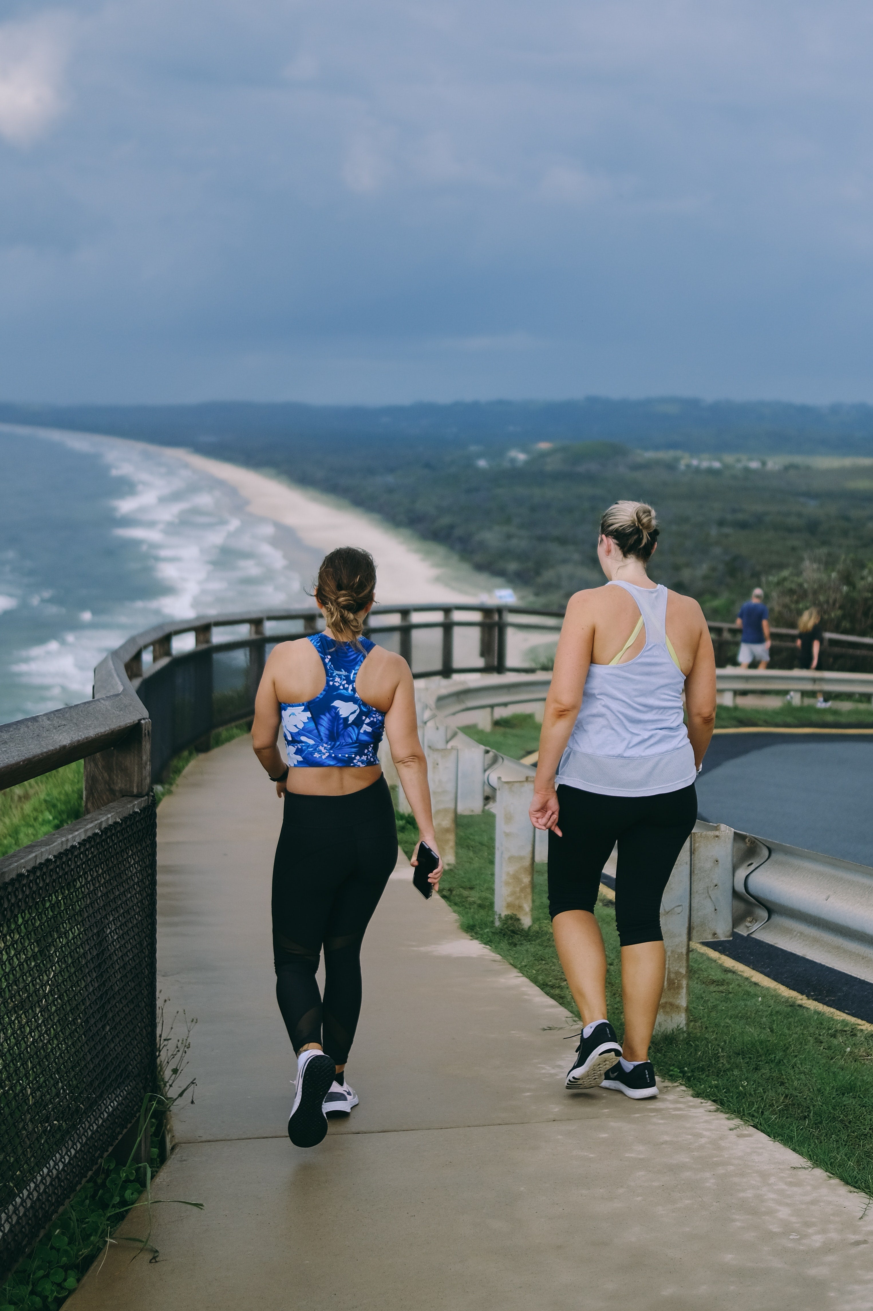 Active women chatting on a walk on a pier overseeing the ocean