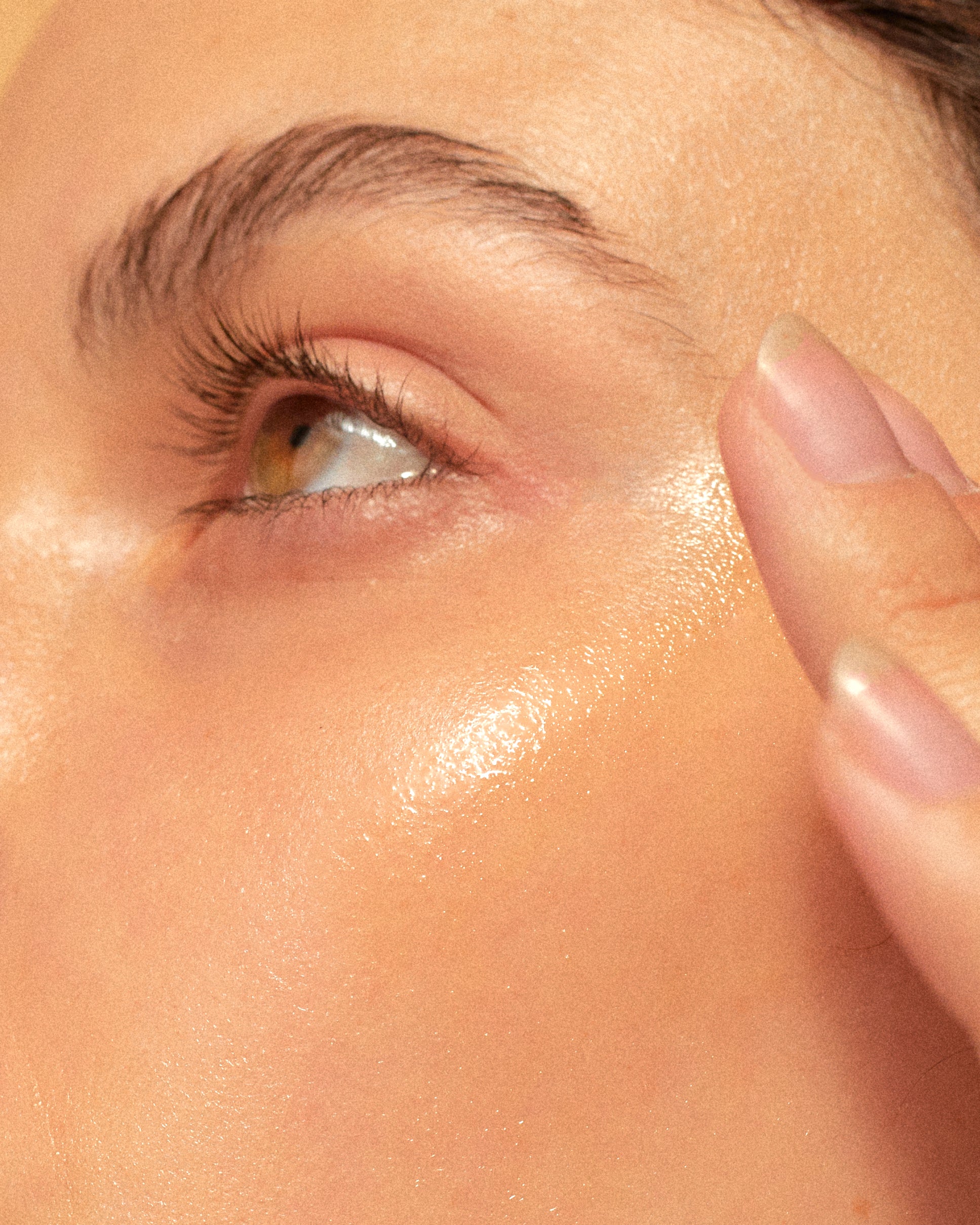 Woman with glowing, clear skin applying Vitamin C Serum