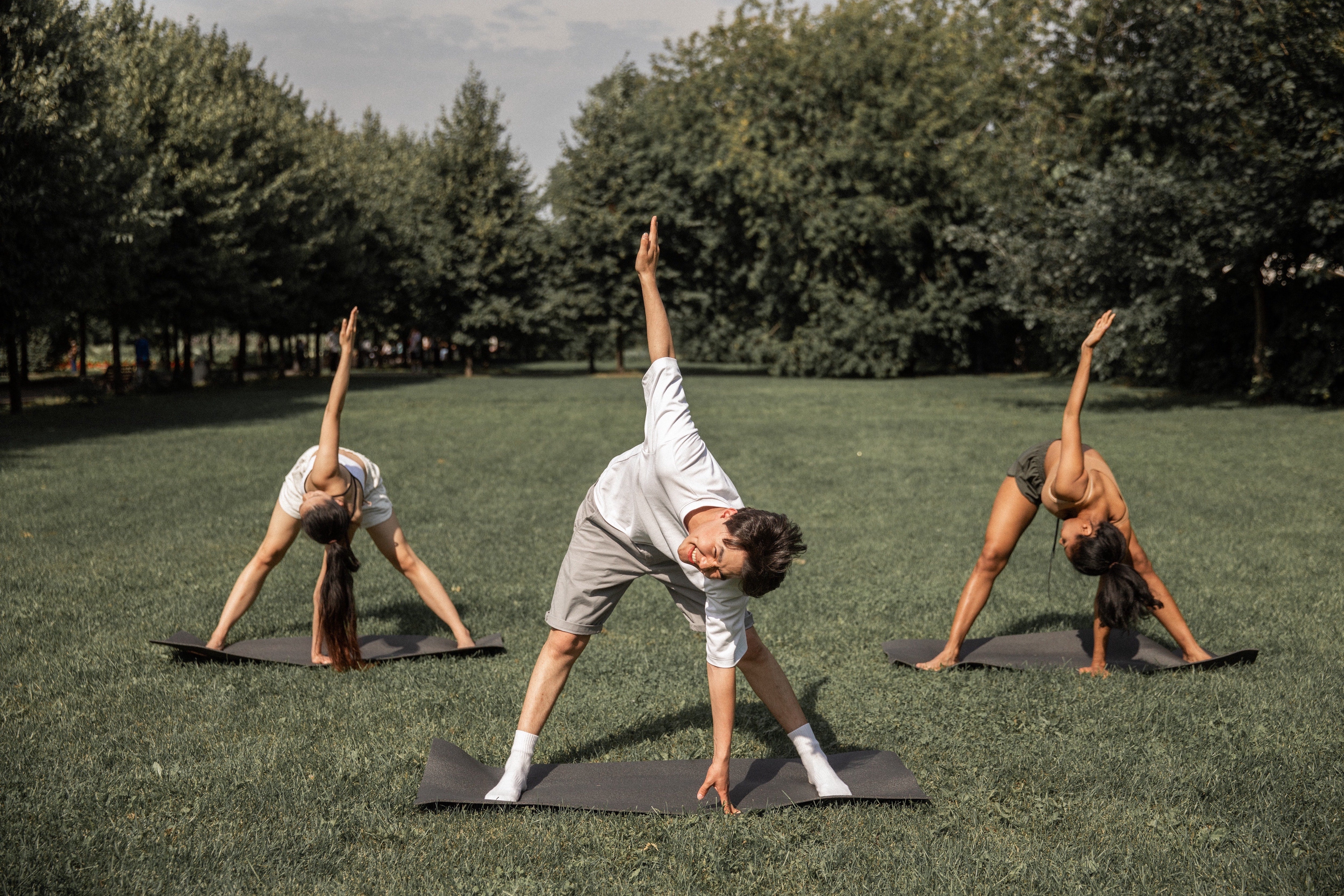 Three friends cheerfully practicing yoga