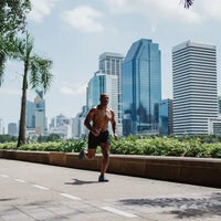 Athletic man running through city