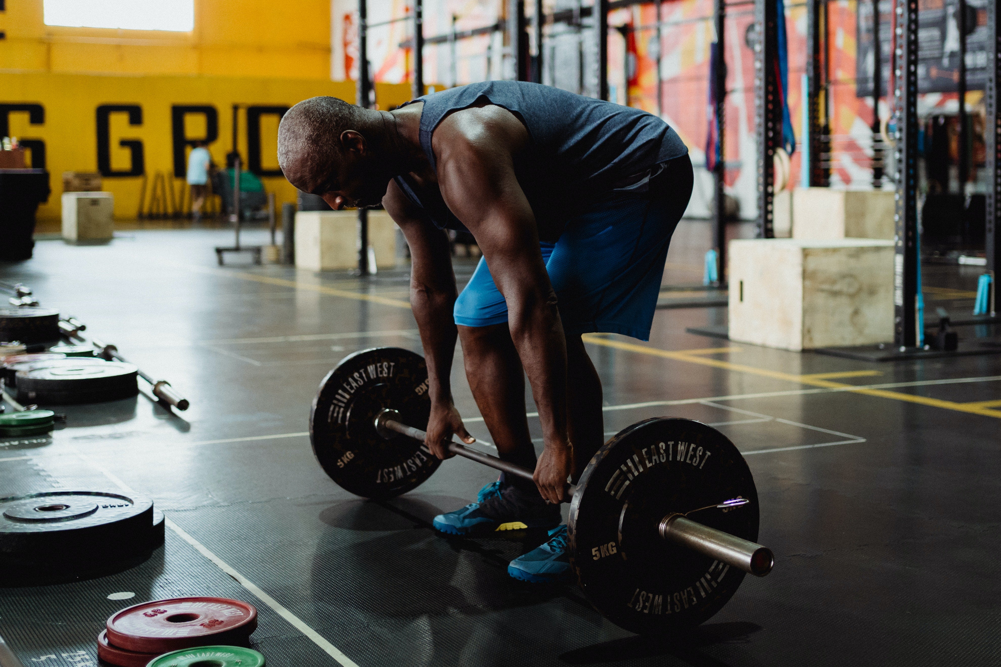 Man weight lifting at the gym and building muscle mass, which is known to help increase metabolism