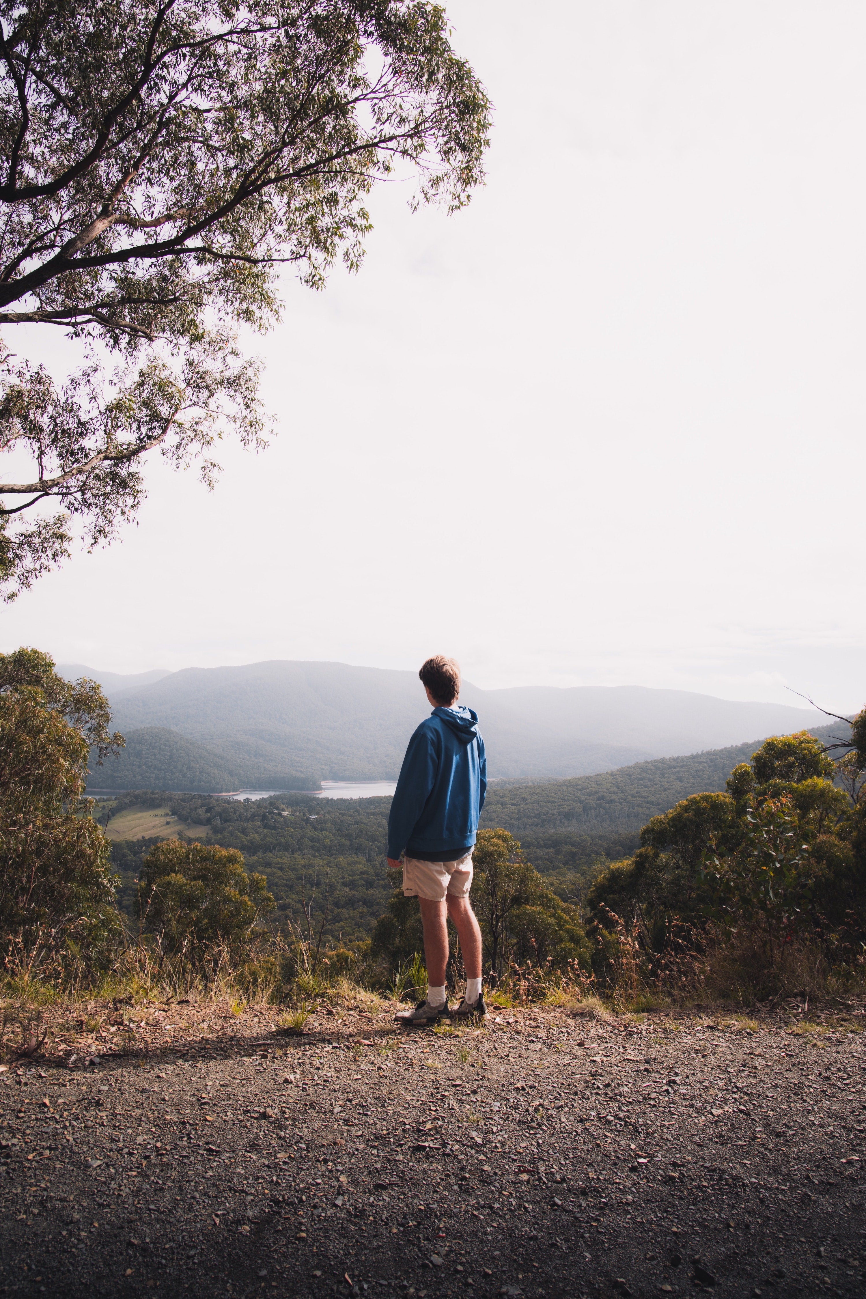 Standing man watching foggy mountains and lake view