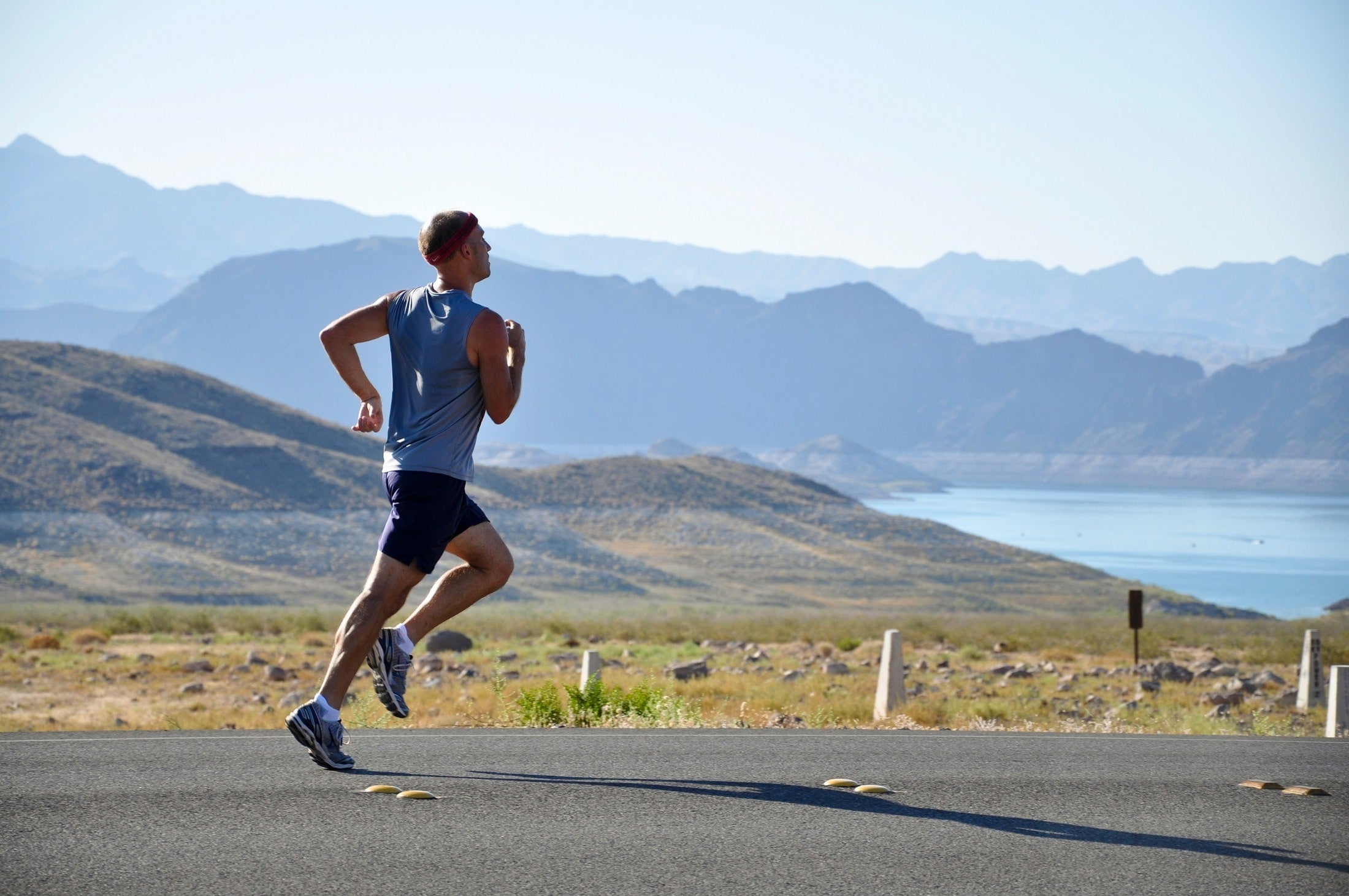 Man on a jog overlooking the mountains and a lake
