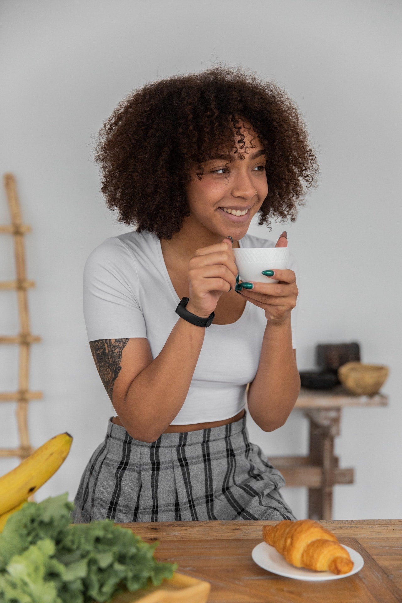 Woman drinking coffee with a croissant 