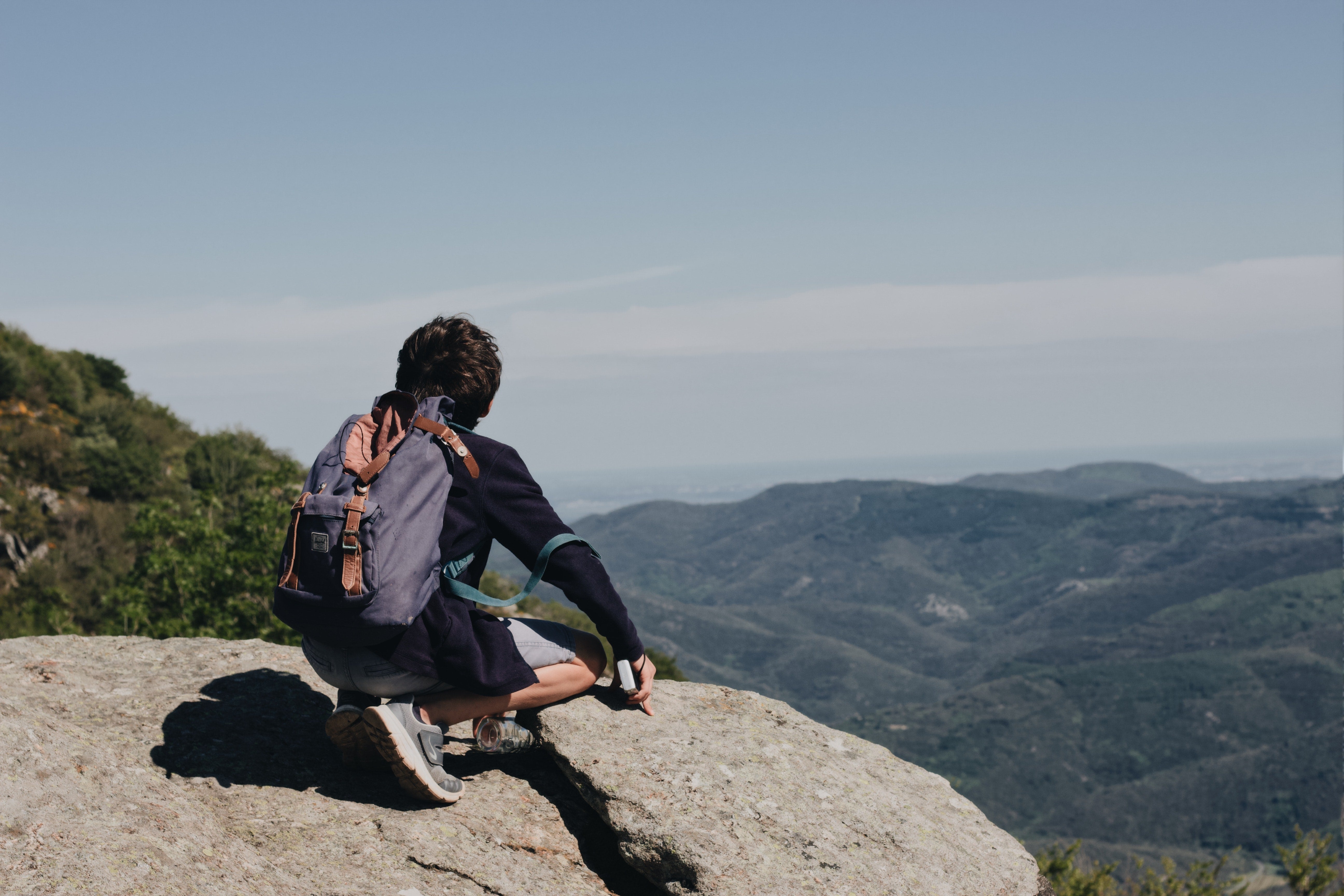 Man on a hike looking at mountain top view