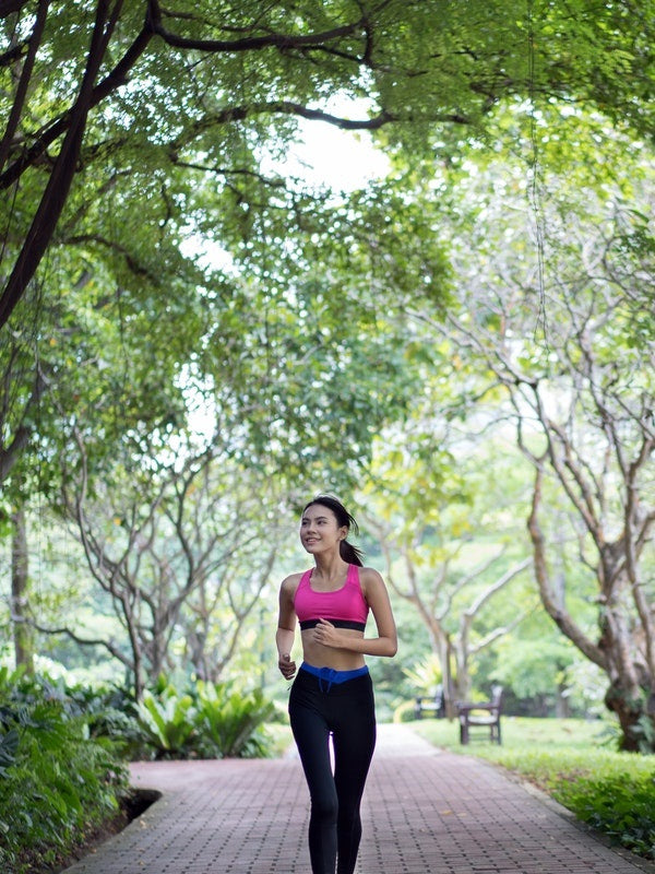 Fit young woman running through park