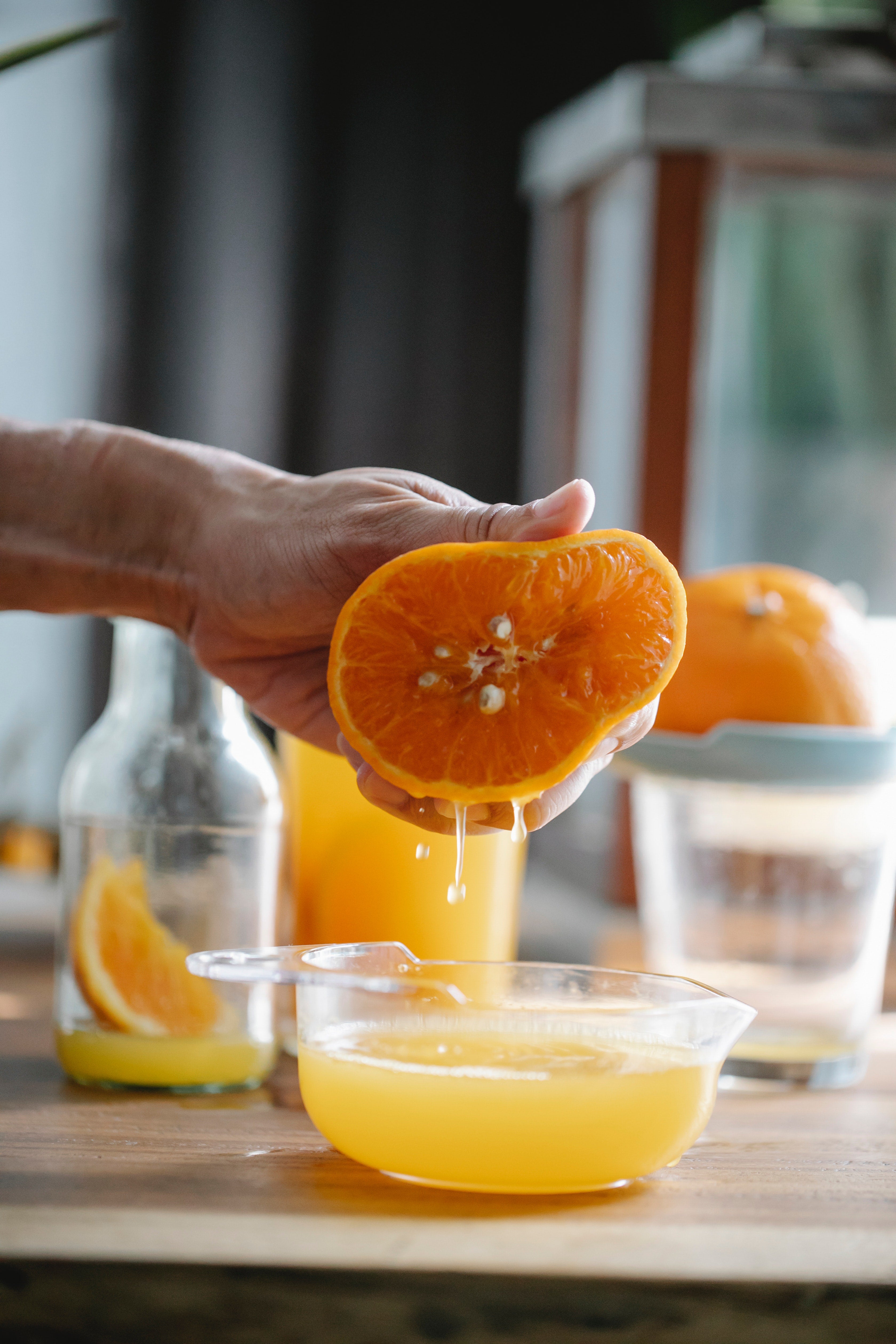 Person squeezing an orange into a bowl