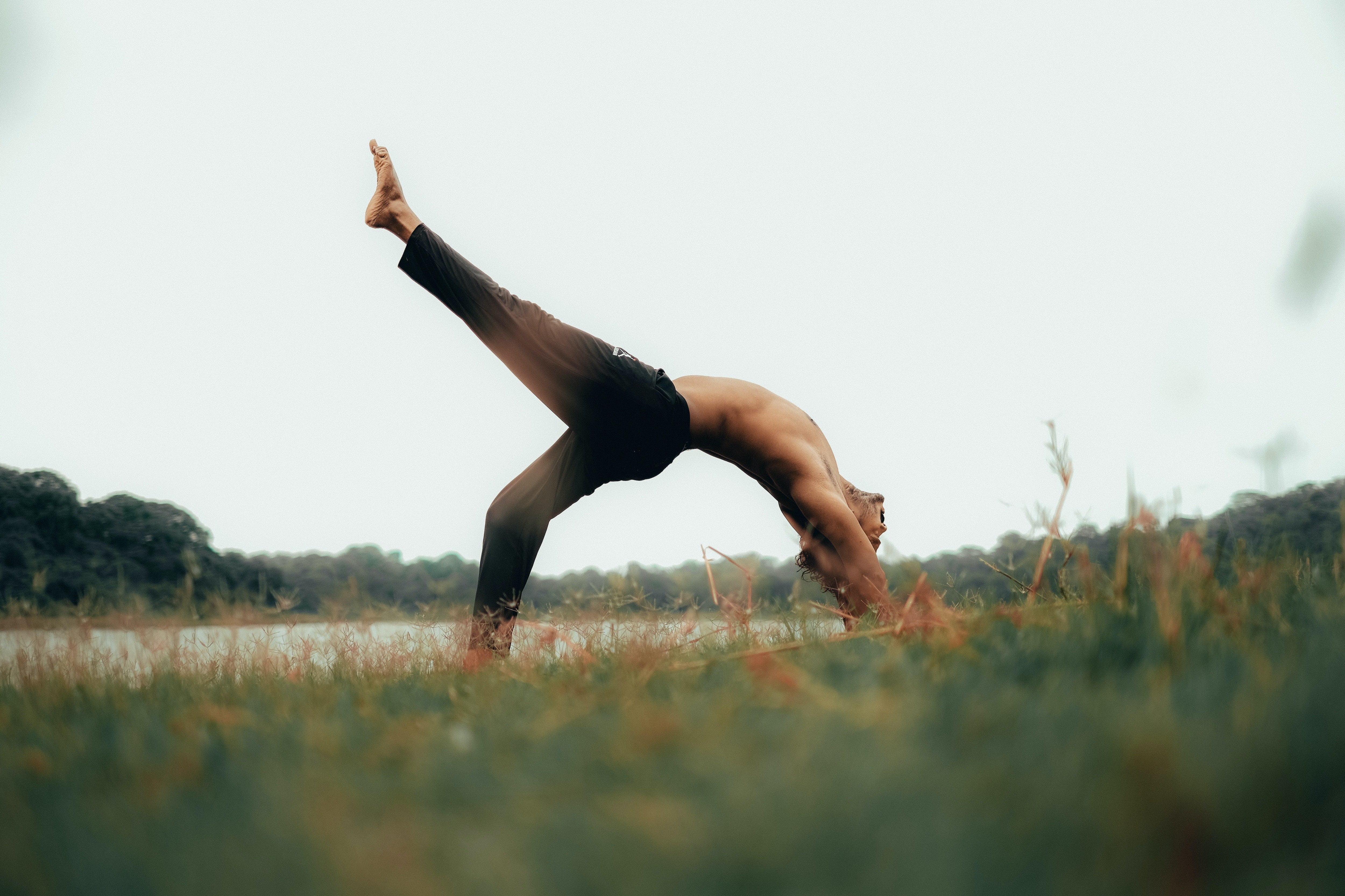 Man doing backbend in a field