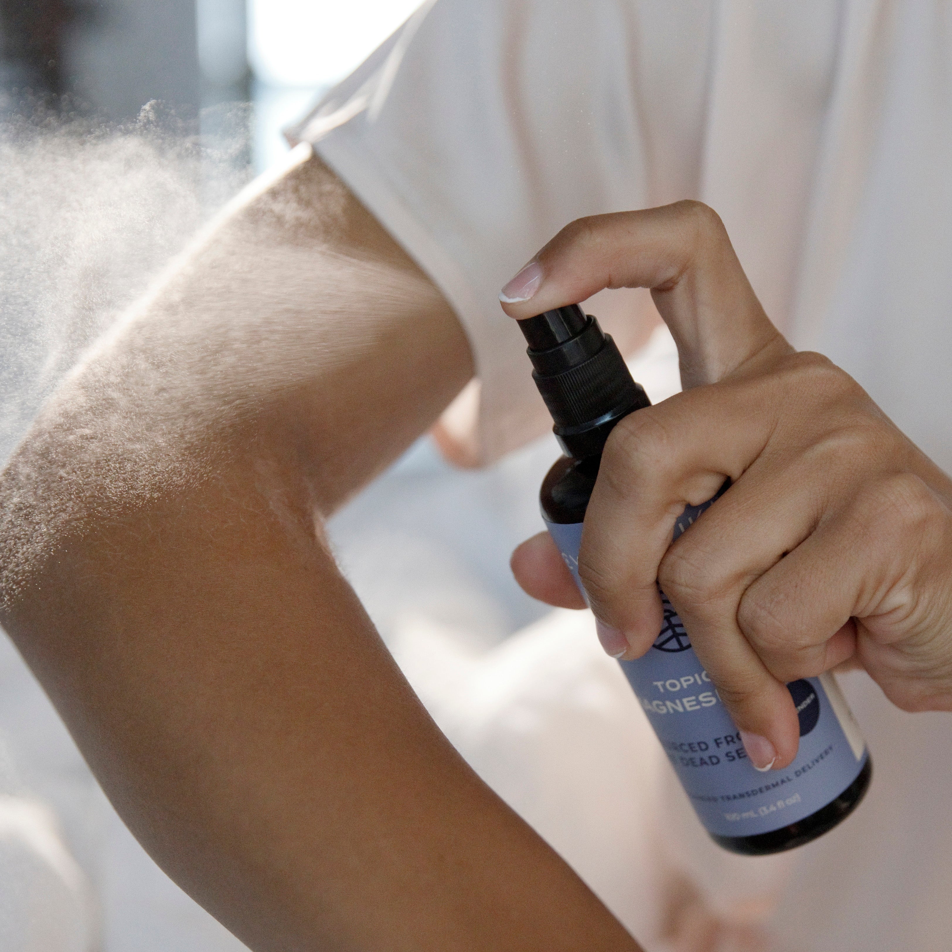 Topical Magnesium Oil Spray Being Sprayed on Arm